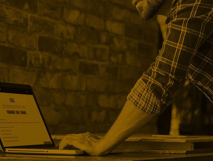 Man looking on his computer at the Poulan pro FAQ Page.