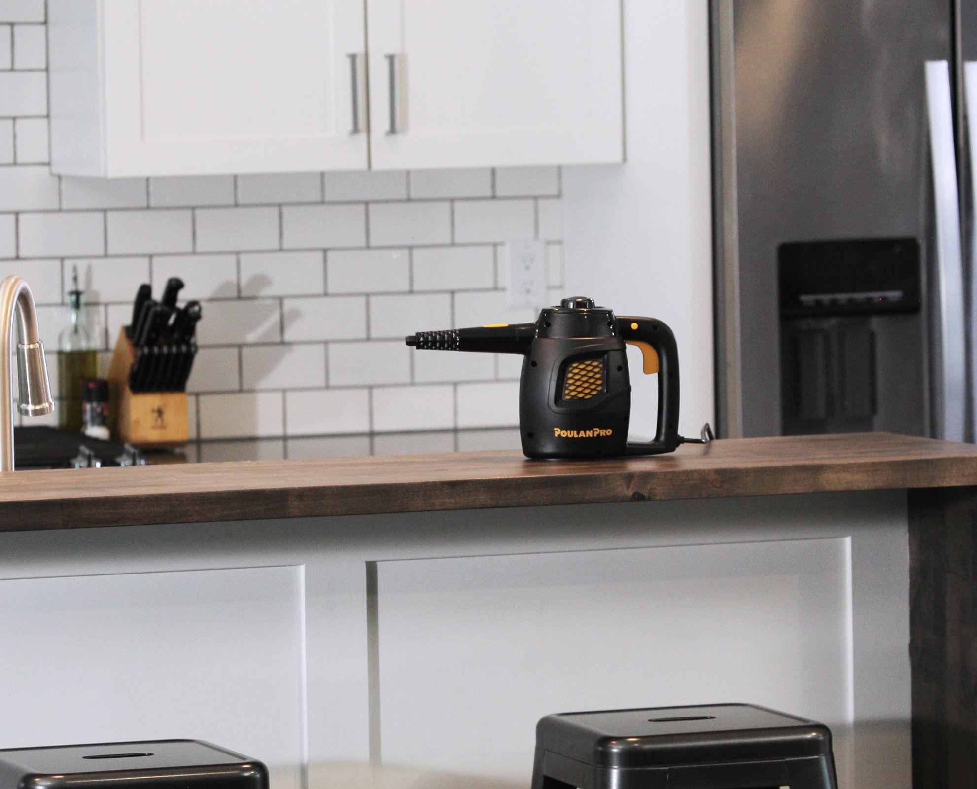 Image of the Poulan Pro PP230 side angle on top of a wooden countertop with white cabinetry underneath. The image contains the cord as well as the trigger for steam.