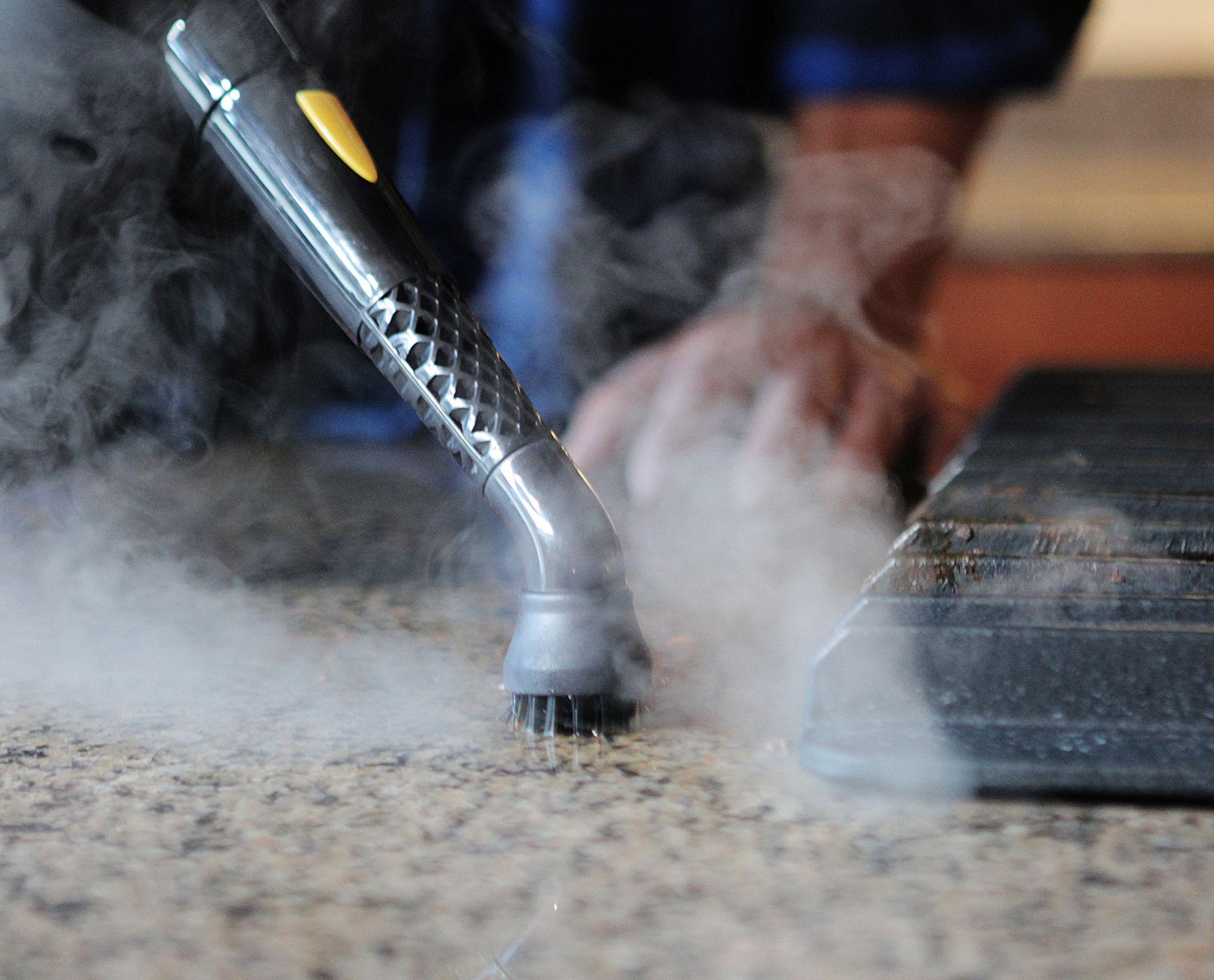 Image of the PP230 steam cleaner being used on counter top highlighting the features of a regular brush head as well as the jet nozzle.