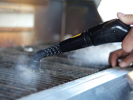 Image of the PP330 steam cleaner being used on a dirty grill highlighting the features of a Brass brush head getting the tough grease off, and the simple nozzle that the brush head is attached too, and the simplicity of use.