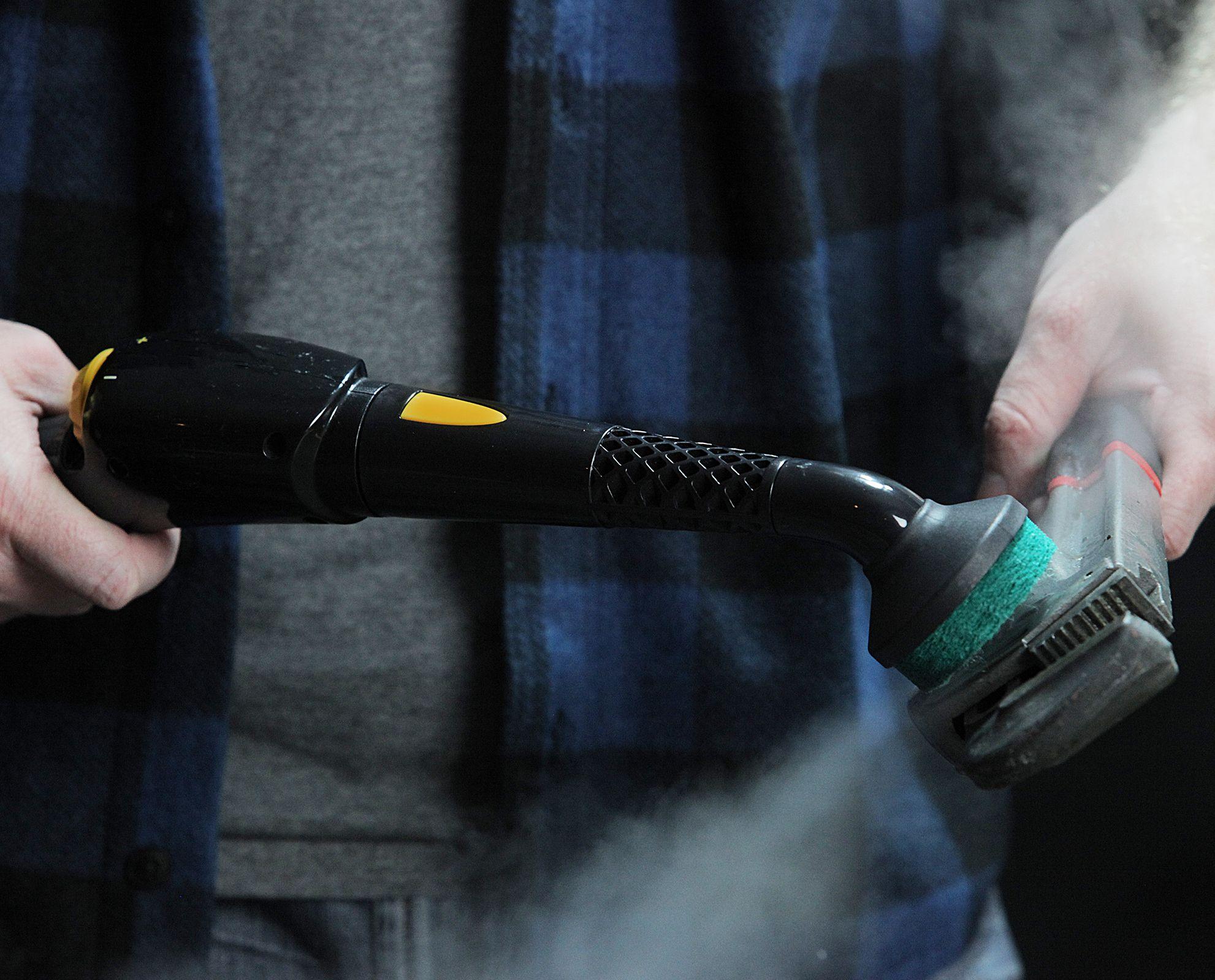 Image of the PP330 steam cleaner being used on a rusty wrench highlighting the features of a scrubbing brush head, and the simple nozzle that the brush head is attached too, and the simplicity of use.