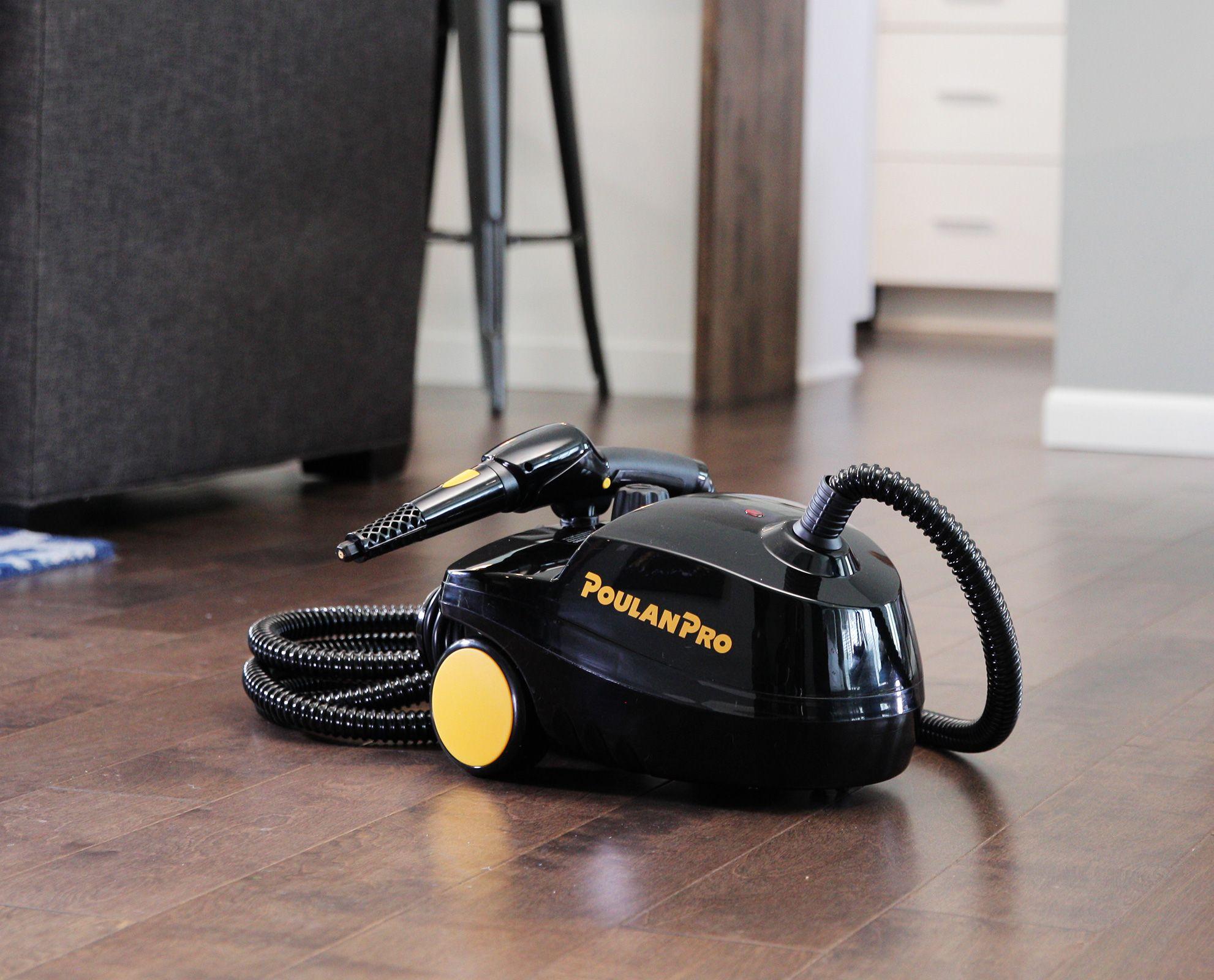 Image of the Poulan Pro PP350 side angle on hardwood floor in a living room. The image contains a wrapped up hose with the jet nozzle attachment on top of the steam cleaner.
