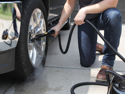 Image of the PP350 steam cleaner being used on the wheels of a large vehicle highlighting the features of a regular brush head as well as length of hose and simplicity of use.