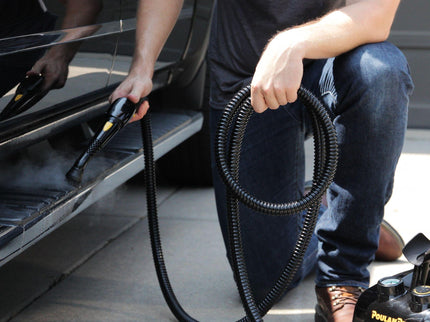 Image of the PP350 steam cleaner being used on a running board of a large vehicle highlighting the features of a regular brush head as well as length of hose as well as simplicity of use.