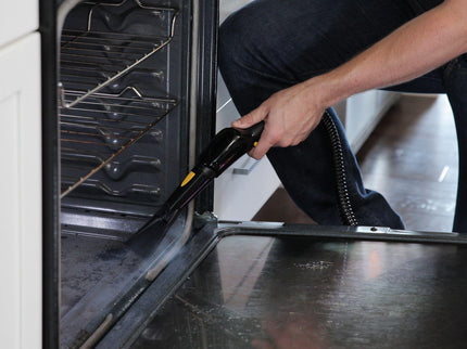 mage of the PP350 steam cleaner being used on the bottom of a dirty oven highlighting the features of the scraper getting the grime off of the bottom of the oven.