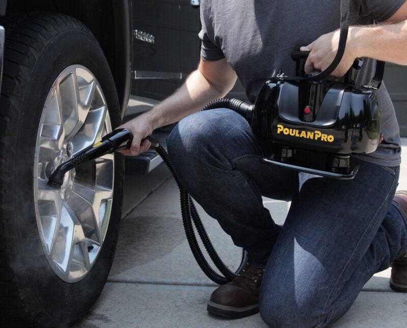 Man using a Poulan Pro PP270 Portable Power Steam Cleaner on a truck tire